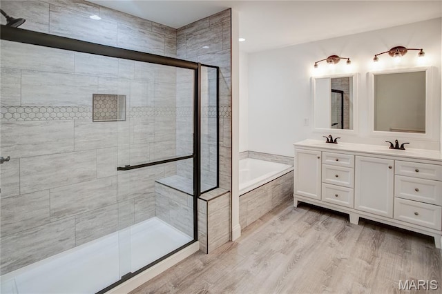 1127 Redwing Ct, Grafton, IL 62037 - bathroom with a garden tub, a shower stall, double vanity, and wood finished floors