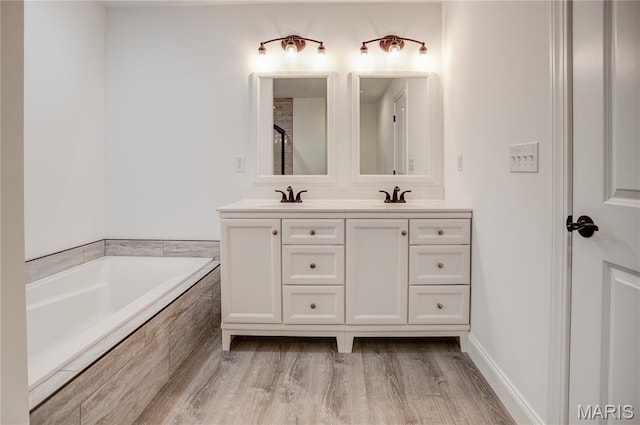 1127 Redwing Ct, Grafton, IL 62037 - bathroom with double vanity, a garden tub, wood finished floors, and a shower
