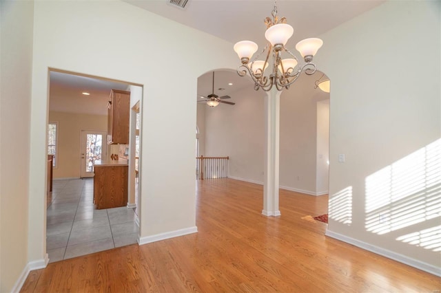 814 Marti Dr, Rolla, MO 65401 - unfurnished dining area with a ceiling fan, a chandelier, arched walkways, and light wood-type flooring