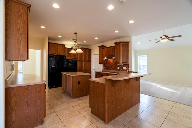 814 Marti Dr, Rolla, MO 65401 - kitchen with black appliances, under cabinet range hood, a peninsula, backsplash, and a kitchen island