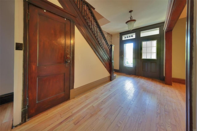 3834 De Tonty St, Saint Louis, MO 63110 - foyer entrance with stairway, light wood-style flooring, and baseboards