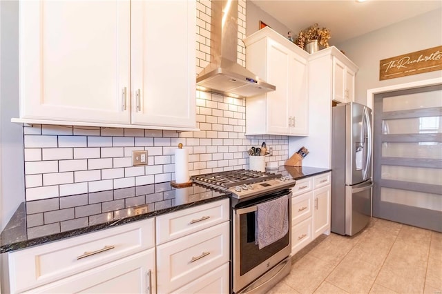 101 Lauren Grace Ct, Elsberry, MO 63343 - kitchen with stainless steel appliances, wall chimney range hood, white cabinetry, light tile patterned floors, and dark stone countertops