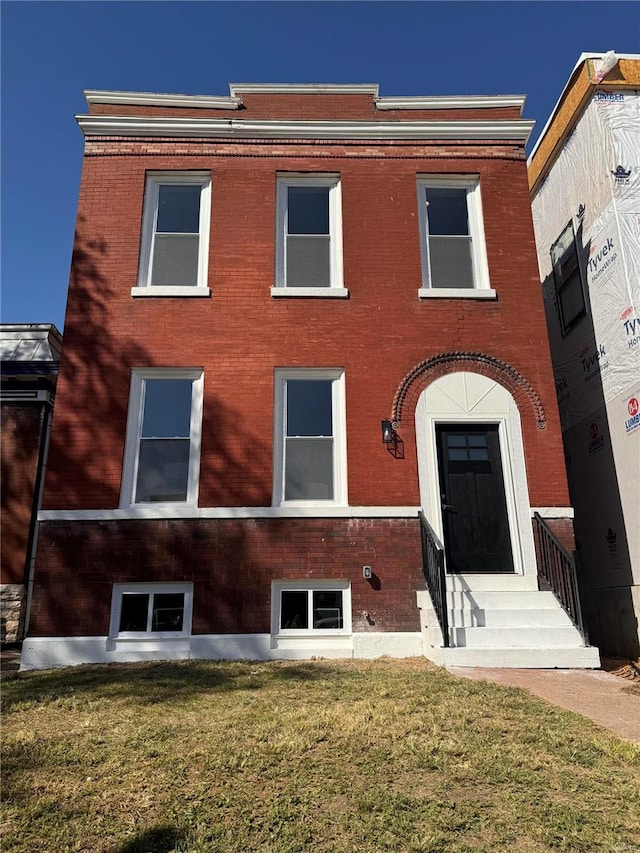 4211 Norfolk Ave, Saint Louis, MO 63110 - view of front of property featuring brick siding, a front lawn, and entry steps