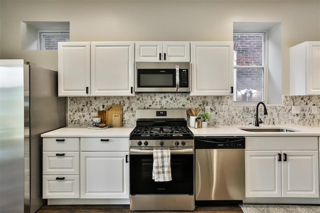 4211 Norfolk Ave, Saint Louis, MO 63110 - kitchen with appliances with stainless steel finishes, a sink, light countertops, and white cabinets