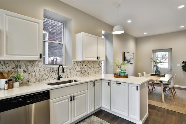 4211 Norfolk Ave, Saint Louis, MO 63110 - kitchen with stainless steel dishwasher, a sink, a peninsula, decorative backsplash, and white cabinets