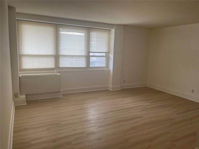 unfurnished room featuring light wood finished floors and baseboards