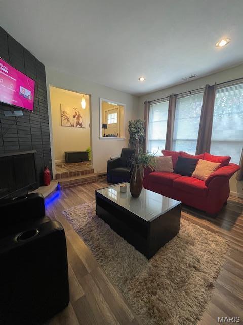 725 Valencia Ave, Saint Louis, MO 63138 - living room featuring wood finished floors, recessed lighting, baseboards, and an accent wall