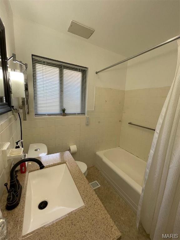 725 Valencia Ave, Saint Louis, MO 63138 - bathroom with toilet, tile walls, shower / bath combo with shower curtain, a wainscoted wall, and vanity