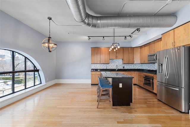 4901 Washington Blvd Unit 2C, Saint Louis, MO 63108 - kitchen with appliances with stainless steel finishes, baseboards, a sink, dark countertops, and a kitchen island