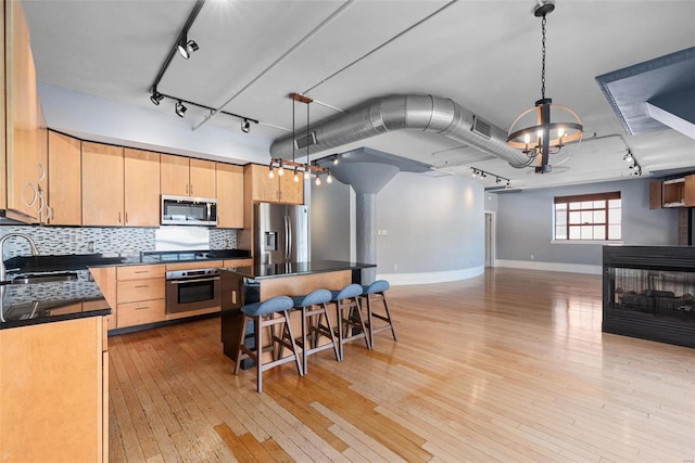 4901 Washington Blvd Unit 2C, Saint Louis, MO 63108 - kitchen featuring appliances with stainless steel finishes, a sink, dark countertops, baseboards, and open floor plan