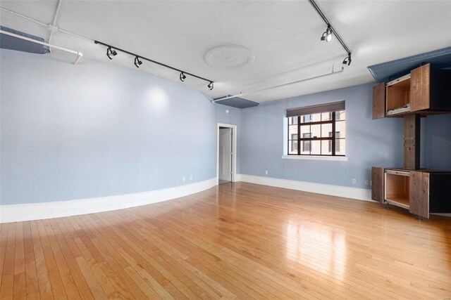 4901 Washington Blvd Unit 2C, Saint Louis, MO 63108 - unfurnished living room with track lighting, light wood-type flooring, and baseboards