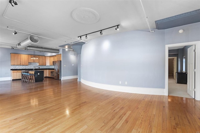 4901 Washington Blvd Unit 2C, Saint Louis, MO 63108 - unfurnished living room with baseboards, light wood finished floors, a sink, and track lighting