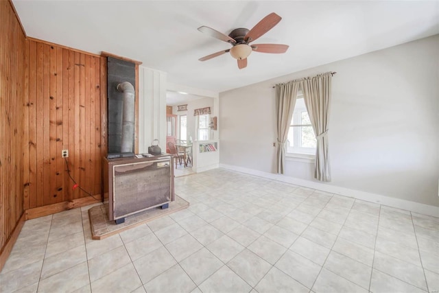 2251 County Road 6670, Salem, MO 65560 - unfurnished living room with wooden walls, a ceiling fan, baseboards, and a wood stove
