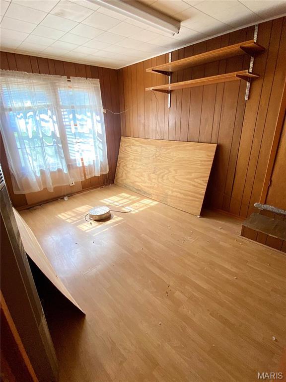 101 E Cedar St, Bertrand, MO 63823 - empty room with wooden walls and light wood-style flooring