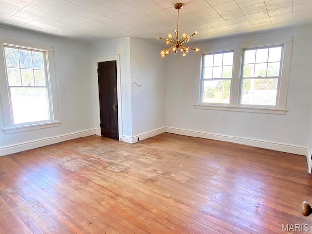 101 E Cedar St, Bertrand, MO 63823 - spare room featuring plenty of natural light, light wood-type flooring, and a chandelier