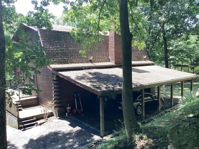 1102 County Road 5, Rockwood, IL 62280 - view of side of property with a shingled roof, log exterior, and a carport