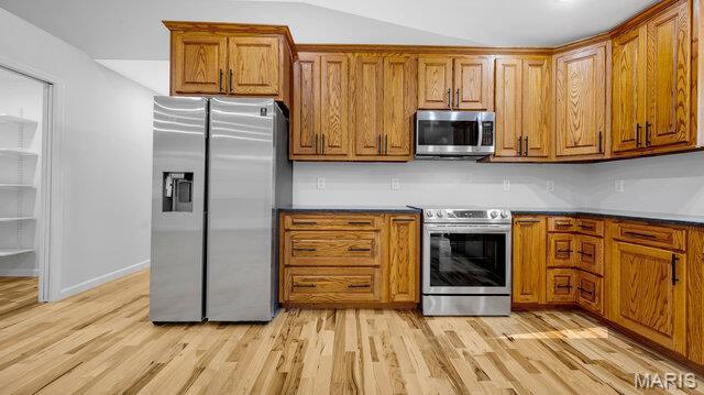 18305 Joerling Ln, Marthasville, MO 63357 - kitchen featuring appliances with stainless steel finishes, brown cabinets, light wood-style floors, and baseboards