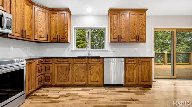 18305 Joerling Ln, Marthasville, MO 63357 - kitchen featuring appliances with stainless steel finishes, brown cabinetry, a sink, light wood-type flooring, and healthy amount of natural light