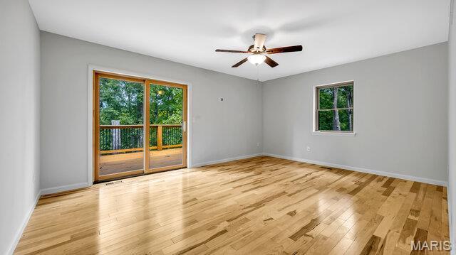 18305 Joerling Ln, Marthasville, MO 63357 - empty room featuring healthy amount of natural light, ceiling fan, wood finished floors, and baseboards