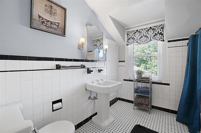 401 Elm St, Washington, MO 63090 - bathroom featuring tile walls, toilet, a shower with curtain, tile patterned flooring, and a wainscoted wall