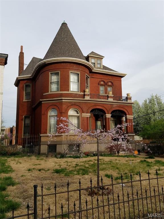 2712 S Compton Ave, Saint Louis, MO 63118 - rear view of property with a fenced front yard, a chimney, and brick siding