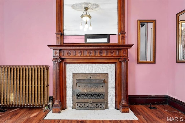 2712 S Compton Ave, Saint Louis, MO 63118 - detailed view of radiator heating unit, a tile fireplace, and wood finished floors