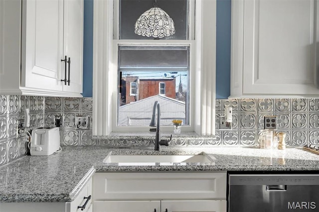 2712 S Compton Ave, Saint Louis, MO 63118 - kitchen featuring stainless steel dishwasher, a sink, decorative backsplash, and white cabinets
