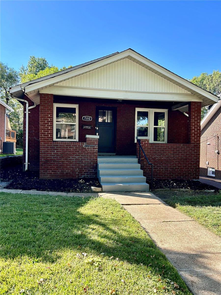 7332 Bruno Ave, Saint Louis, MO 63117 - bungalow featuring a porch, a front yard, brick siding, and central AC