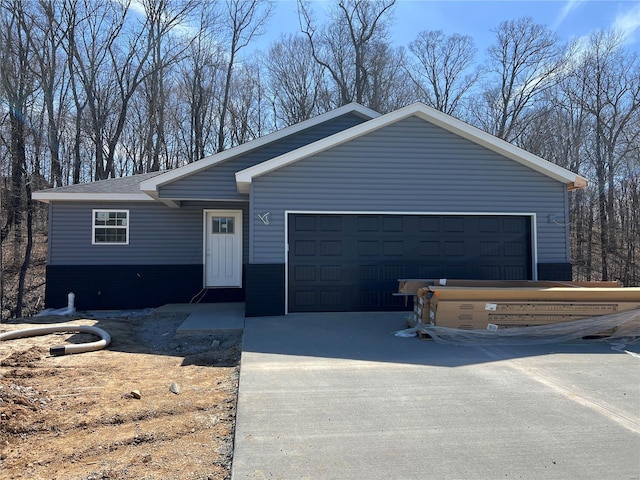single story home featuring concrete driveway and a garage