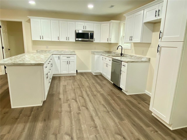 317 E Cypress St, Charleston, MO 63834 - kitchen featuring appliances with stainless steel finishes, a sink, wood finished floors, white cabinets, and recessed lighting