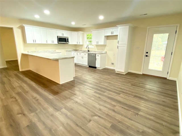 317 E Cypress St, Charleston, MO 63834 - kitchen with stainless steel appliances, a peninsula, white cabinets, baseboards, and wood finished floors