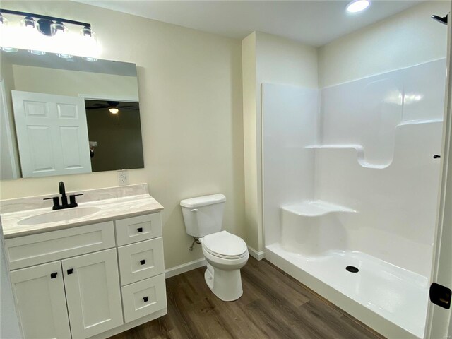 317 E Cypress St, Charleston, MO 63834 - full bath with wood finished floors, toilet, baseboards, vanity, and a shower