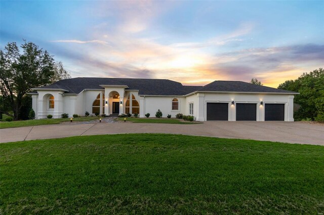 237 Kensington Ln, Cape Girardeau, MO 63701 - view of front of house featuring driveway, a lawn, an attached garage, and stucco siding