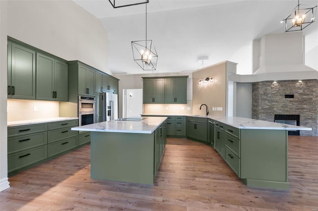 237 Kensington Ln, Cape Girardeau, MO 63701 - kitchen with green cabinets, stainless steel appliances, high vaulted ceiling, and a chandelier