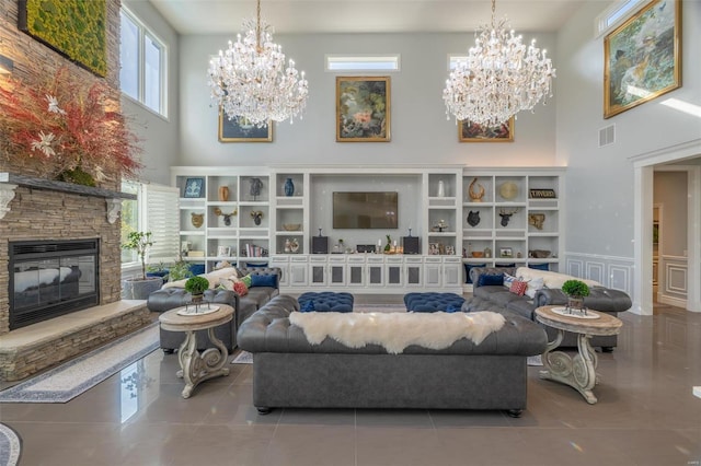 2471 Alpine Cove Dr, Innsbrook, MO 63390 - sitting room with a high ceiling, a chandelier, tile patterned floors, a stone fireplace, and wainscoting