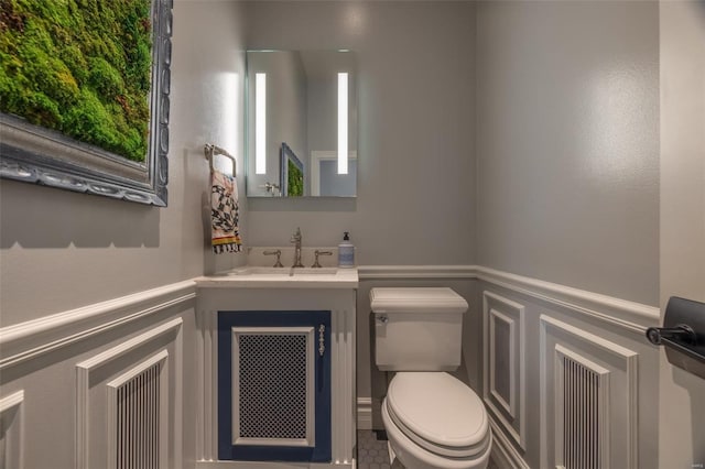 2471 Alpine Cove Dr, Innsbrook, MO 63390 - bathroom featuring toilet, a decorative wall, vanity, a wainscoted wall, and healthy amount of natural light