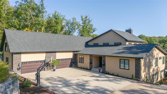 2471 Alpine Cove Dr, Innsbrook, MO 63390 - view of front facade with roof with shingles, driveway, a chimney, and an attached garage