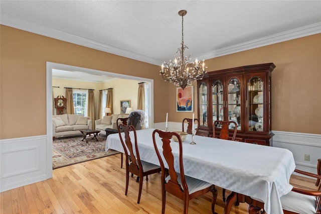 1125 N Franklin St, Litchfield, IL 62056 - dining area featuring a wainscoted wall, crown molding, a chandelier, and light wood-style flooring