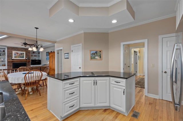 1125 N Franklin St, Litchfield, IL 62056 - kitchen with a fireplace, light wood finished floors, white cabinets, ceiling fan, and ornamental molding