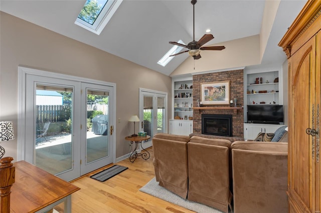 1125 N Franklin St, Litchfield, IL 62056 - living room with a skylight, a brick fireplace, ceiling fan, light wood-style flooring, and high vaulted ceiling