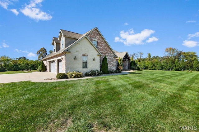 view of side of property with concrete driveway, stone siding, and a lawn