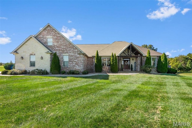view of front facade featuring a front lawn, brick siding, and stone siding