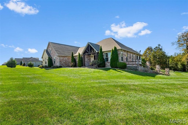 view of front facade with a front yard and stone siding