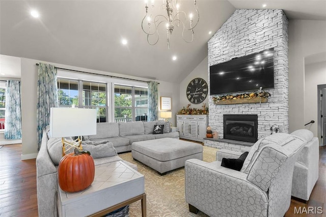 living room featuring hardwood / wood-style flooring, high vaulted ceiling, a chandelier, a fireplace, and recessed lighting
