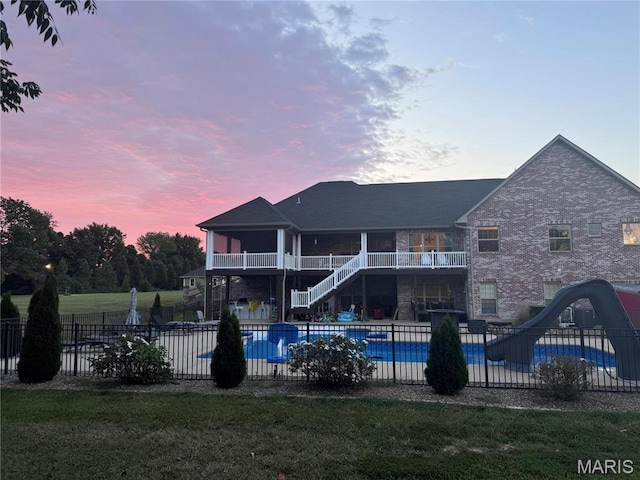 rear view of house featuring stairway, a balcony, and a patio