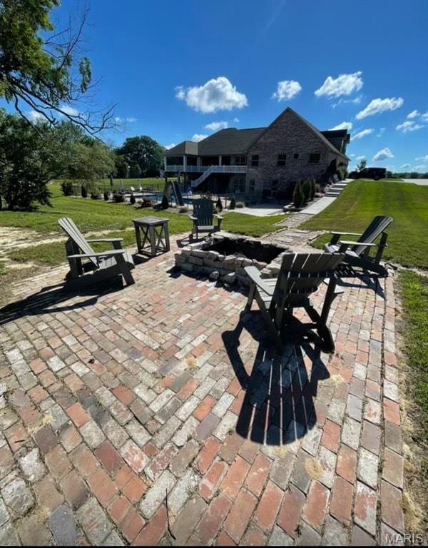 view of home's community featuring a patio area, a yard, and a fire pit