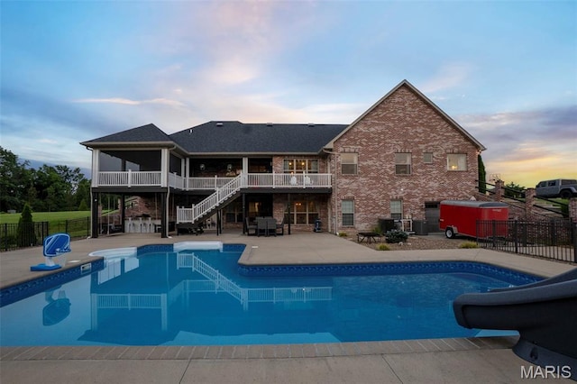 165 Kingsborough Ct, Jackson, MO 63755 - pool at dusk with stairs, a water slide, and a patio