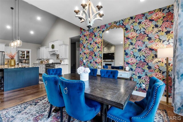165 Kingsborough Ct, Jackson, MO 63755 - dining space featuring a chandelier, arched walkways, wood finished floors, high vaulted ceiling, and wallpapered walls