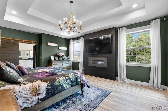 165 Kingsborough Ct, Jackson, MO 63755 - bedroom with a tray ceiling, a barn door, light wood-type flooring, a chandelier, and recessed lighting