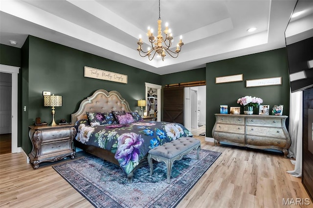 165 Kingsborough Ct, Jackson, MO 63755 - bedroom featuring a barn door, a tray ceiling, wood finished floors, a chandelier, and recessed lighting